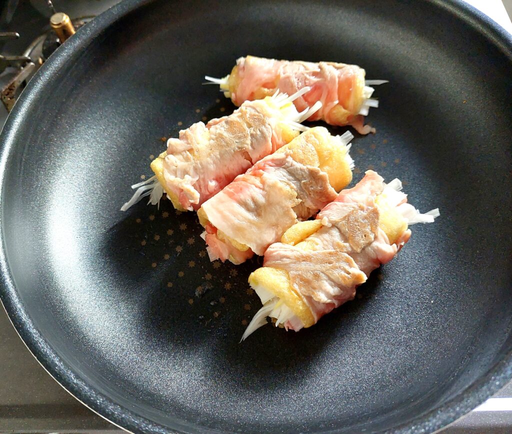 豚肉とお揚げのネギ巻き　フライパンで焼いている画像