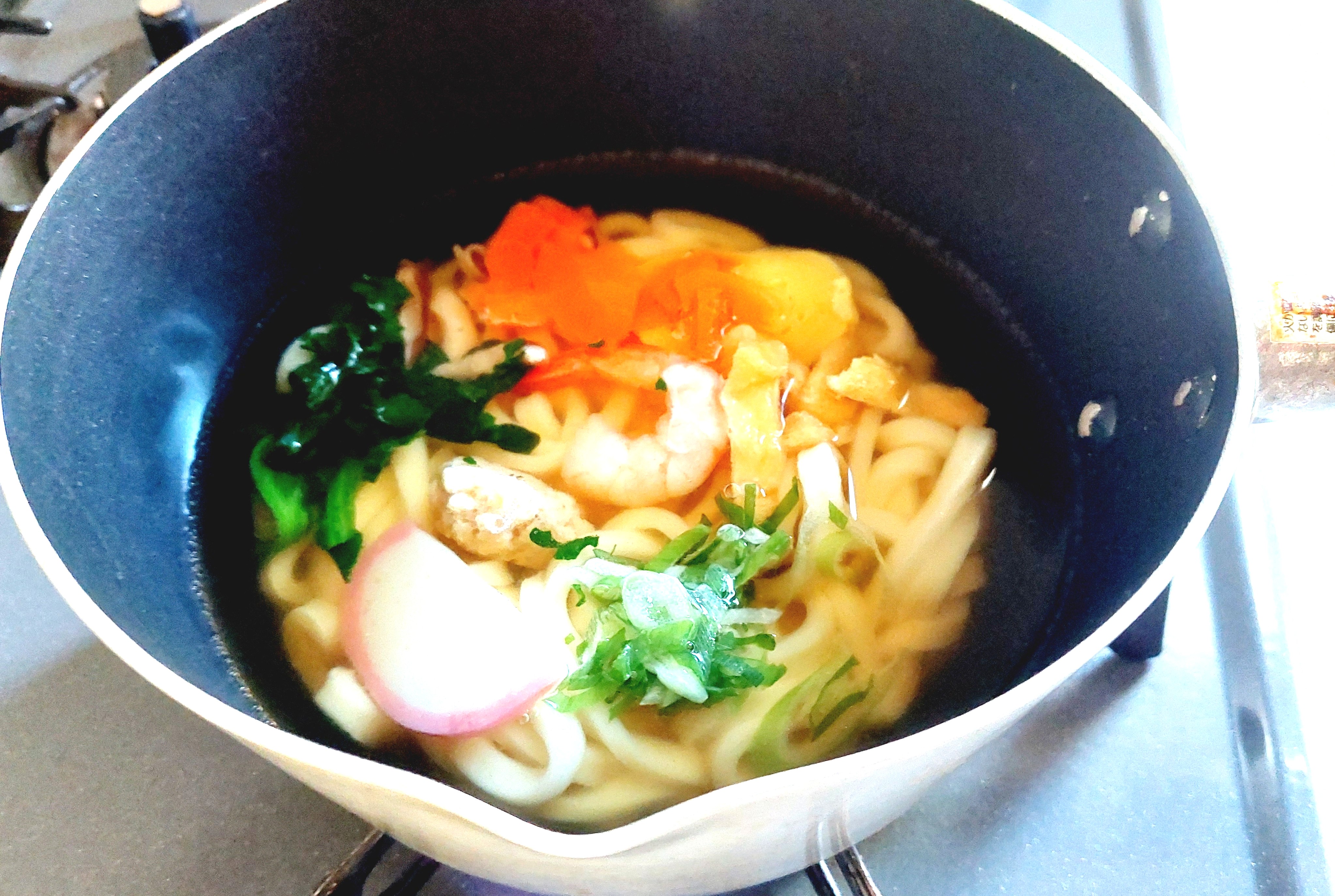 コープ「関西風合わせだしが自慢１０種具材の鍋焼うどん」鍋で煮込む